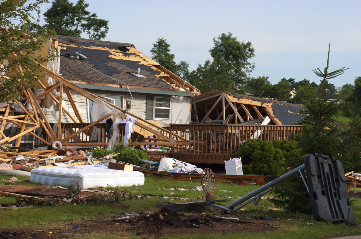 Insurance adjuster inspecting tornado damage to a residential home